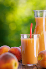 glass of peach juice with ripe fruits