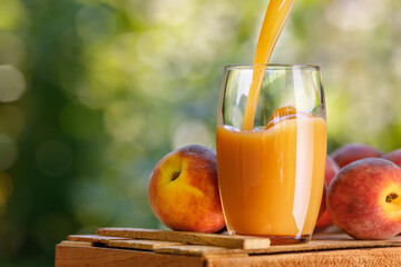 fresh peach juice pouring into glass outdoors