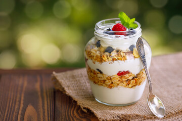 granola with greek yogurt and berries in glass jar