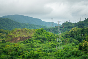 A high voltage electricity tower with powerline cable passing the highland rural environment with...