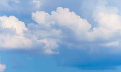 White, thick clouds on a background of blue sky, wallpaper.