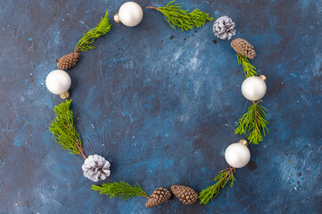 traditional winter festive decor - a Christmas wreath of pine branches, Christmas tree decorations and cones. Minimalism. There are no people in the photo. There is an empty space for your insert.