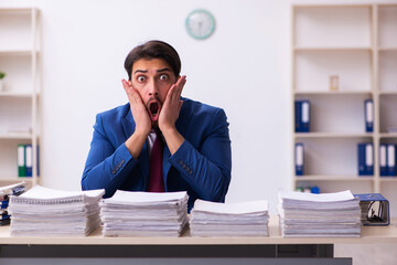 Young businessman employee and too much work in the office