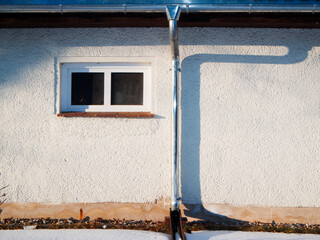 House wall with rain gutter and downpipe