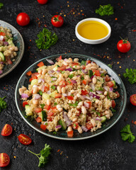 Quinoa white bean salad with cherry tomatoes, cucumber, red onion and herbs. Healthy vegan food