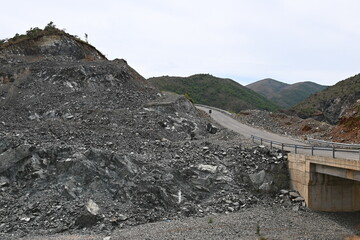 Straße am Stausee des Fluss Fan in Albanien mit Steinen, Steinbruch