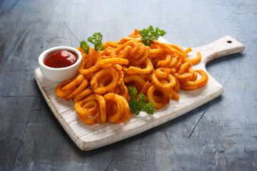 Spicy Curly Fries with ketchup on white wooden board - obrazy, fototapety, plakaty