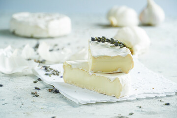 Camembert cheese on a background of garlic and lavender