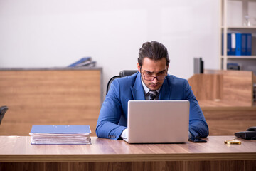 Young male employee sitting at workplace