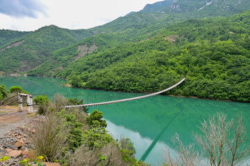 Shkopet Bridge Wooden suspension bridge over the turquoise river Liqeni i Ulzes near Madhesh in...