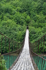 Shkopet Bridge Hängebrücke aus Holz über den türkisen Fluss liqeni i ulzes bei Madhesh in...