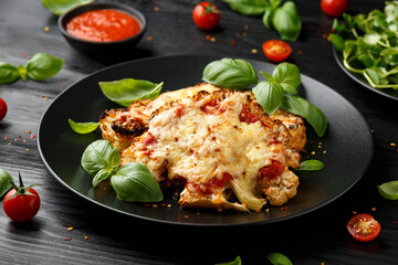 Baked Cauliflower steak with marinara sauce and cheese on plate. Healthy vegetarian food