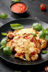 Baked Cauliflower steak with marinara sauce and cheese on plate. Healthy vegetarian food