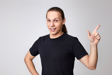 Fototapeta premium Positive young man pointing up at empty space