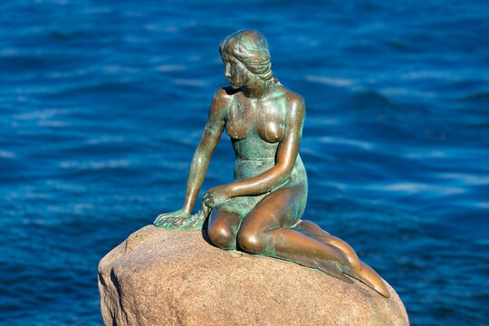 Copenhagen, Denmark - June 28, 2018: The Little Mermaid (Danish: Den lille Havfrue) on a rock by the waterside at the Langelinie promenade. It  is a bronze statue by Edvard Eriksen. 