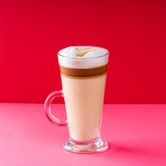 glass of coffee latte movha with milk and foam on red background