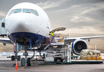 loading cargo into the airplane before departure with nice sky - obrazy, fototapety, plakaty