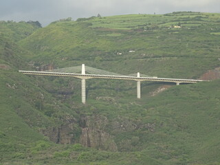Fototapeta premium view of an unusual white metal bridge above the canyon on the tropical island of La Réunion, France