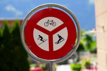 Traffic sign at mountain village Wengen no cycling, no sledge and no skiing on a sunny summer day. Photo taken July 20th, 2021, Lauterbrunnen, Switzerland.