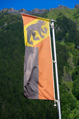 Flag of Canton Bern blowing in the wind at mountain village of Wengen on a sunny summer day. Photo...