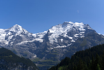 Mount Jungfrau (Virgin) at Bernese highland on a sunny summer day with blue sky background. Photo taken July 20th, 2021, Lauterbrunnen, Switzerland.