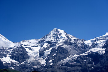 Fototapeta premium Peak Mönch (Monk) at Bernese highland on a sunny summer day with blue sky background. Photo taken July 20th, 2021, Lauterbrunnen, Switzerland.