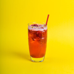 red fresh cocktail smoothie jusice in glass with ice on yellow background. vitamin drink detox