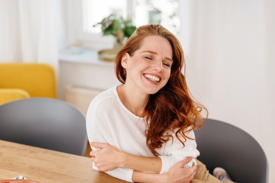 Cute charismatic young redhead woman with a sweet toothy smile