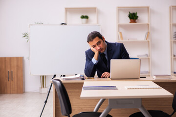 Young male employer in front of white board