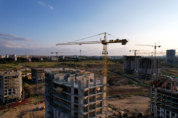 Naklejka premium Сonstruction site with tower cranes during conctruct the high-rise building. Cranes at the pouring concrete into the formwork. Construction and the built environment. Buildings renovation