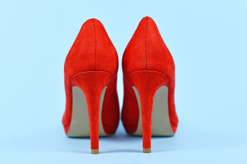 Back view of elegant red synthetic suede leather high heel woman shoes on blue  background