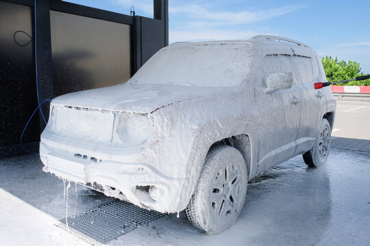 Car in foam at a car wash. Car wash with soap, car wash