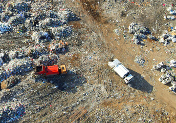 Garbage dump with food waste. Arial view of garbage truck unloads rubbish in landfill. Plastic rubbish dump. Reduce greenhouse gas emissions and methane emissions. Environmental protection