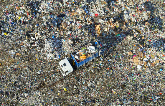 Garbage dump with food waste. Arial view of garbage truck unloads rubbish in landfill. Plastic rubbish dump. Reduce greenhouse gas emissions and methane emissions. Environmental protection