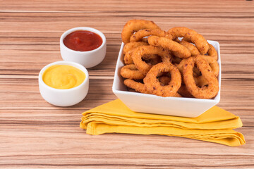 portion of onion rings on wooden background