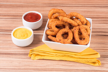 portion of onion rings on wooden background