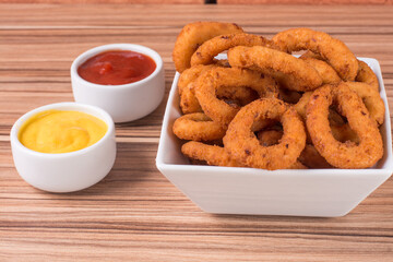 portion of onion rings on wooden background