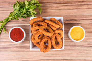 portion of onion rings on wooden background