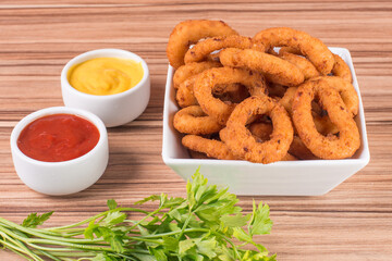 portion of onion rings on wooden background