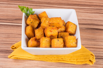 portion of fried polenta on wooden background
