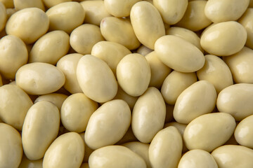 Candies. Almonds in white chocolate. Desserts for candy bars. Little white dragees