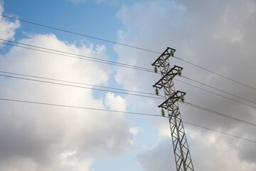 High voltage power lines with a cloudy sky