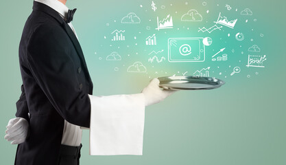 Handsome young waiter in tuxedo holding money icons on tray