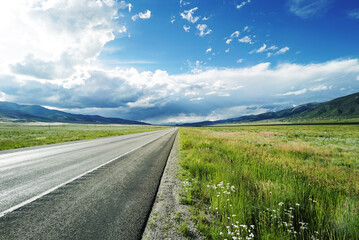 Bright, Sunny Skies Horizon Landscape of Road/Highway and Green, Grassy Field in Rural, Colorado Mountains