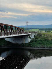New Paltz, NY - USA - July 24, 2021: Vertical sunset view of the Carmine Liberta Memorial Bridge, a two-lane steel through truss bridge over the Wallkill River. It carries New York State Route 299