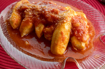 Quenelles from Lyon prepared with tomatoes, onion and aromatic herbs sauce