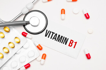 Stethoscope, pills and notebook with Vitamin b1 word on medical desk.