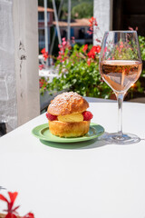 Tarte tropezienne or La Tarte de Saint-Tropez - dessert pastry consisting of filled brioche with cream and fresh berries.and glass of rose wine from Provence, France