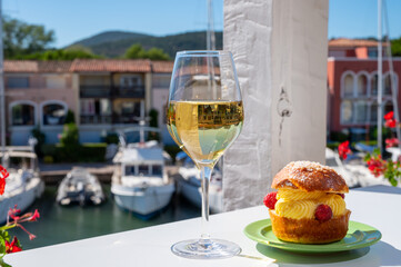 Tarte tropezienne or La Tarte de Saint-Tropez - dessert pastry consisting of filled brioche with cream and fresh berries.and glass of white wine