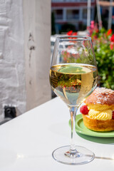 Tarte tropezienne or La Tarte de Saint-Tropez - dessert pastry consisting of filled brioche with cream and fresh berries.and glass of white wine